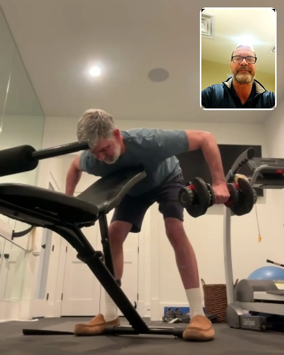 A client rowing in his home gym during a Zoom personal training session with Jamie Atlas