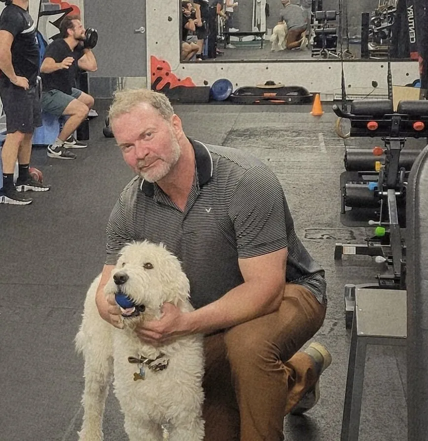 Jamie Atlas with a client's dog on the studio floor mid-session