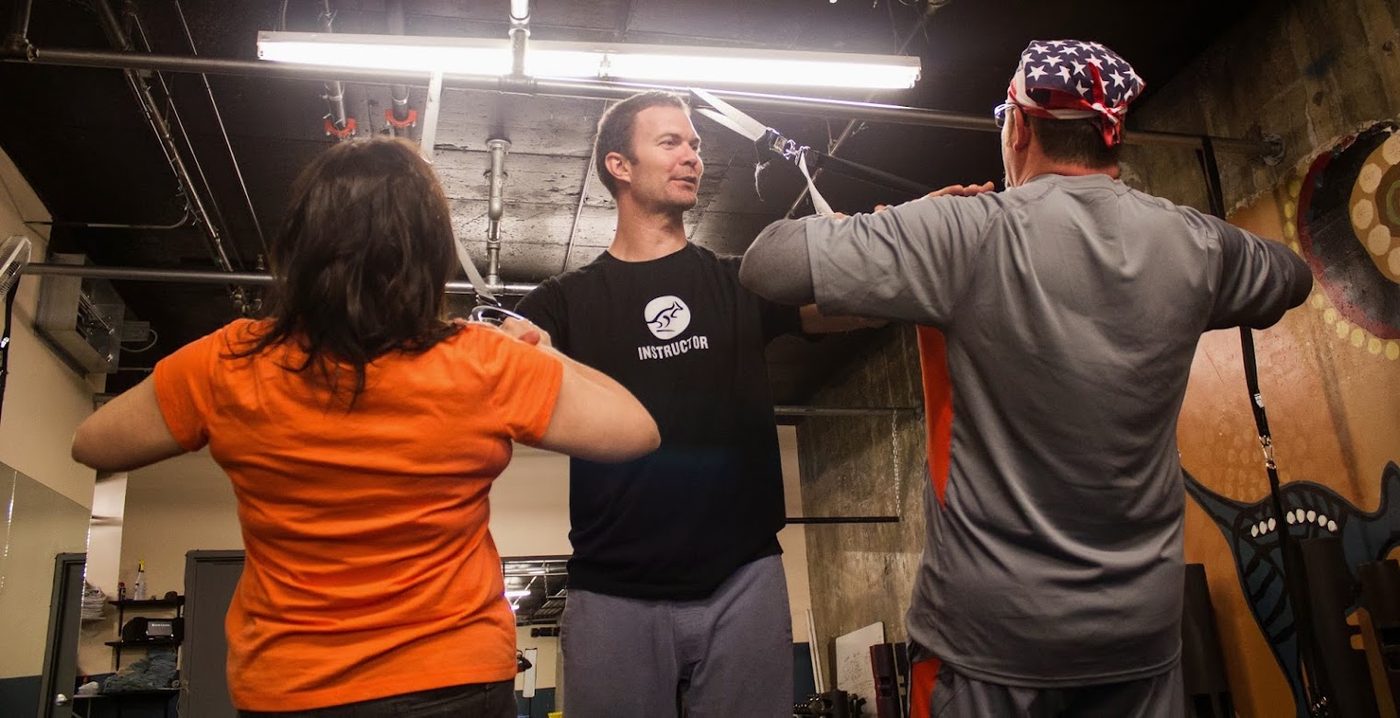Jamie Atlas coaching two clients through a movement assessment at his downtown Denver studio